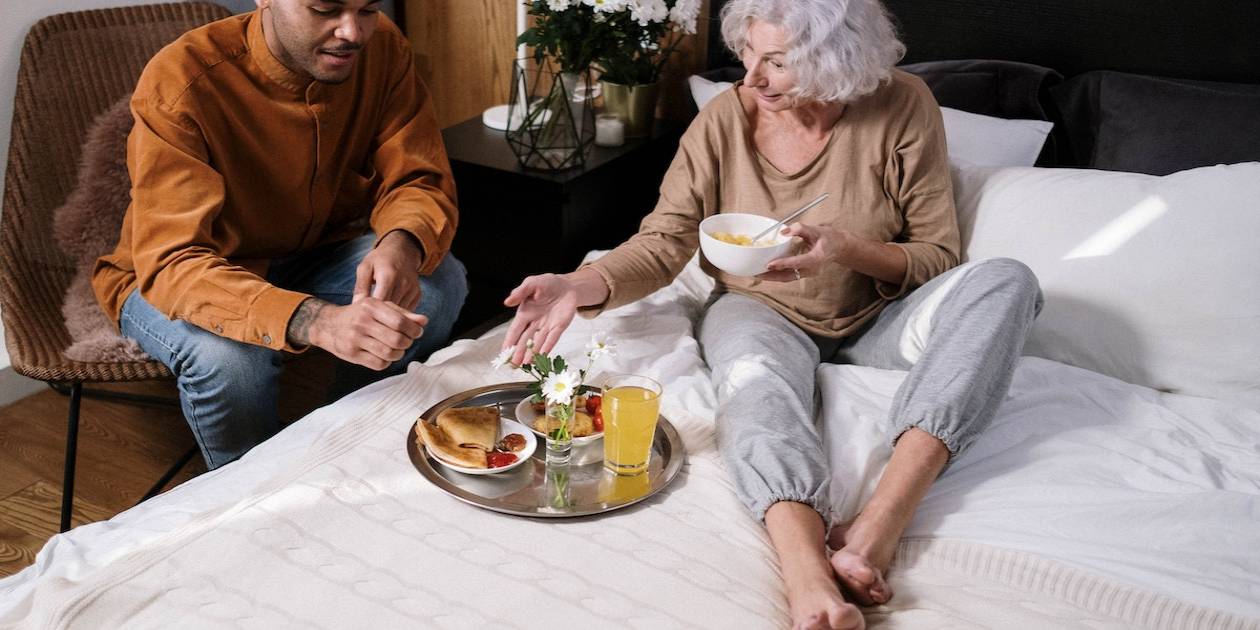 elderly woman eating in bed hospice at home or facility